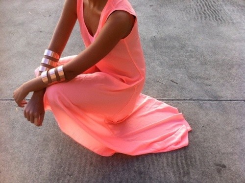 The coral dress and rose gold accessories create a colourful look.